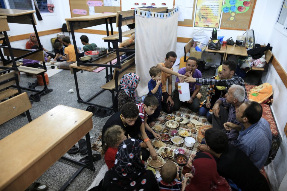 Una familia comparte el iftar (comida al final del día de ayuno de Ramadán) en una escuela de la UNRWA donde se refugió en ciudad de Gaza. (Wissam Nassar, NYT).